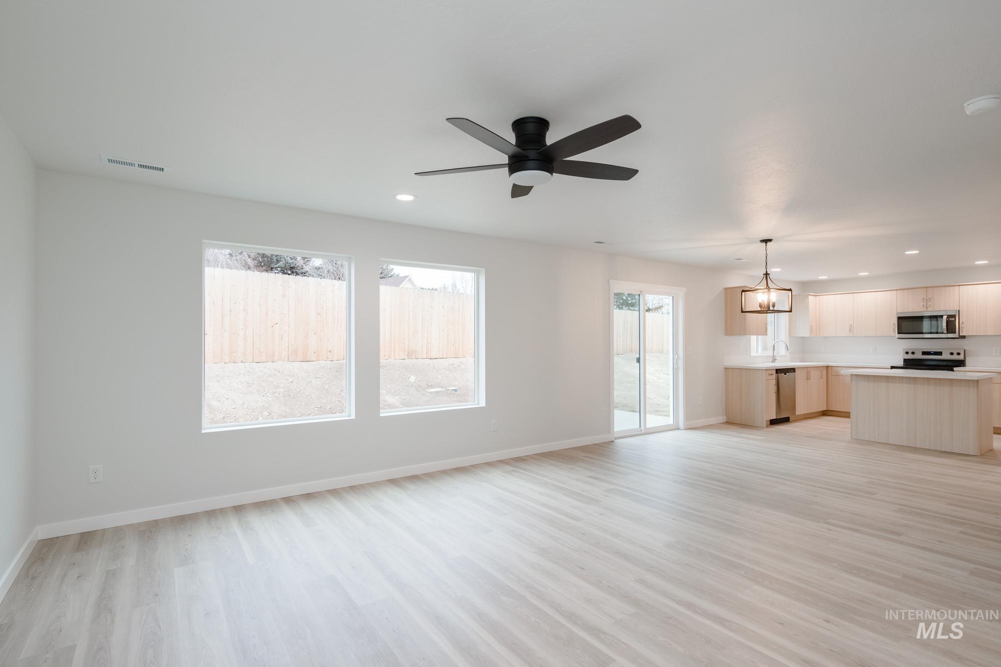 1472 Long Pond Street Middleton, ID 83644 - Photo 9 of 21 Unfurnished living room with recessed lighting, light wood-style floors, a chandelier, and ceiling fan