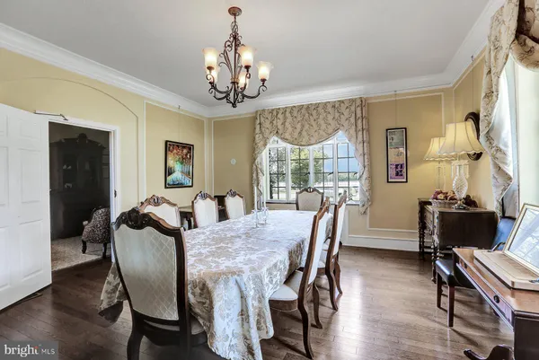 a view of a dining room with furniture large windows and wooden floor