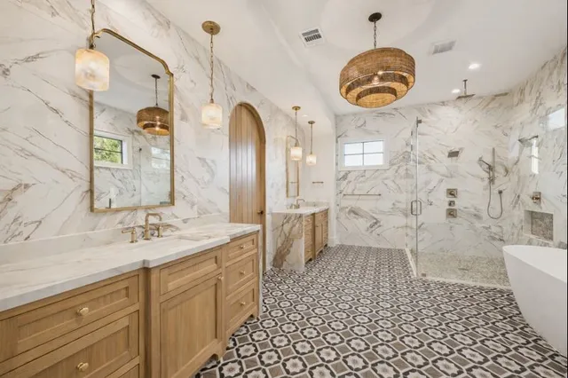 a bathroom with a sink a toilet a large mirror and shower