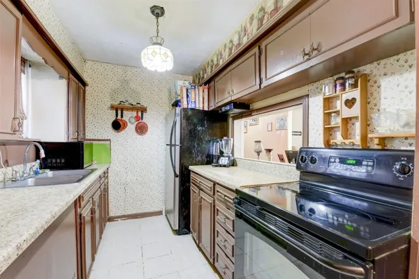a kitchen with stainless steel appliances granite countertop a sink a stove and a refrigerator