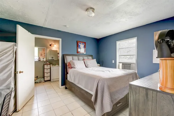 a bedroom with a bed and a refrigerator