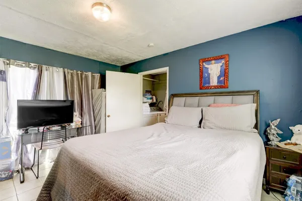 a bedroom with a bed and a flat screen tv