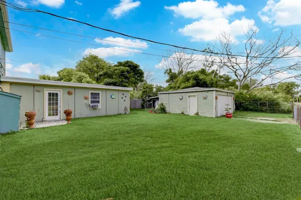 a view of a white house with a yard and a large tree