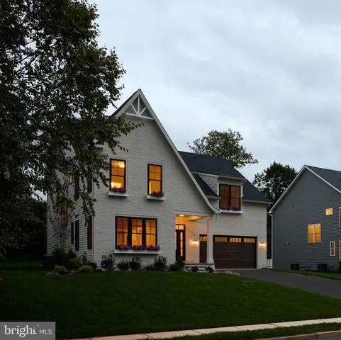a front view of a house with a yard and trees