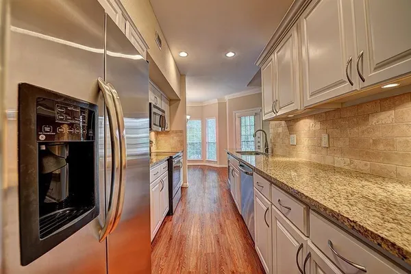 a view of a kitchen with a sink and wooden floor