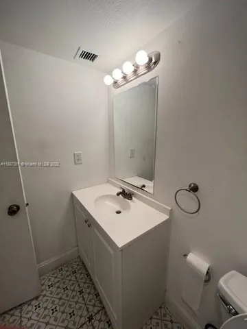 a bathroom with a sink a toilet a mirror and shower