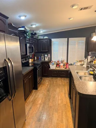 a kitchen with stainless steel appliances granite countertop a sink a stove and a refrigerator