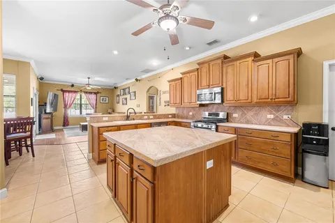 a kitchen with stainless steel appliances kitchen island granite countertop a sink and cabinets