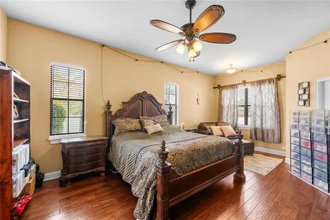a bedroom with a bed a dresser and wooden floor