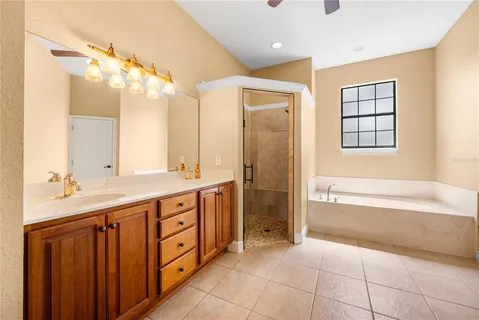 a spacious bathroom with a double vanity sink a large mirror and a bathtub