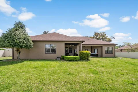 a view of a house with a yard and fence