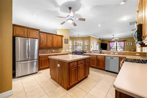 a kitchen with stainless steel appliances granite countertop a stove top oven a refrigerator a sink and dishwasher
