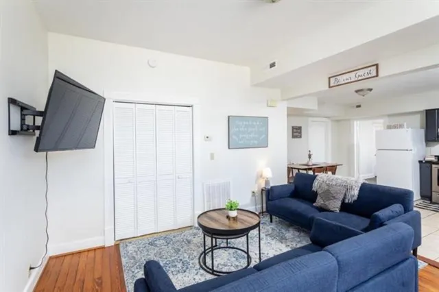 a kitchen with a refrigerator a stove a microwave a dining table and chairs with wooden floor