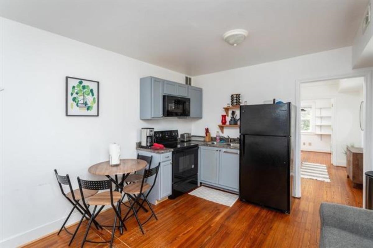 600 East Main Street Waynesboro, VA 22980 - Photo 22 of 33 a kitchen with a refrigerator a stove a microwave a dining table and chairs with wooden floor