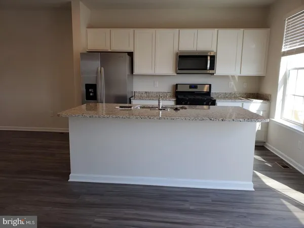a kitchen with stainless steel appliances granite countertop a stove a sink a refrigerator and a microwave