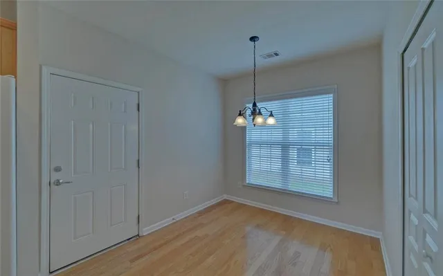 a view of a room with a window and wooden floor