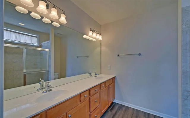 a bathroom with a glass shower door and a window