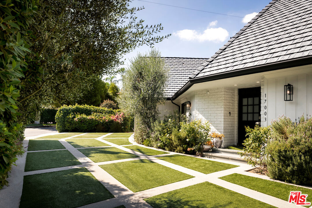 a view of a white house with a yard table and chairs