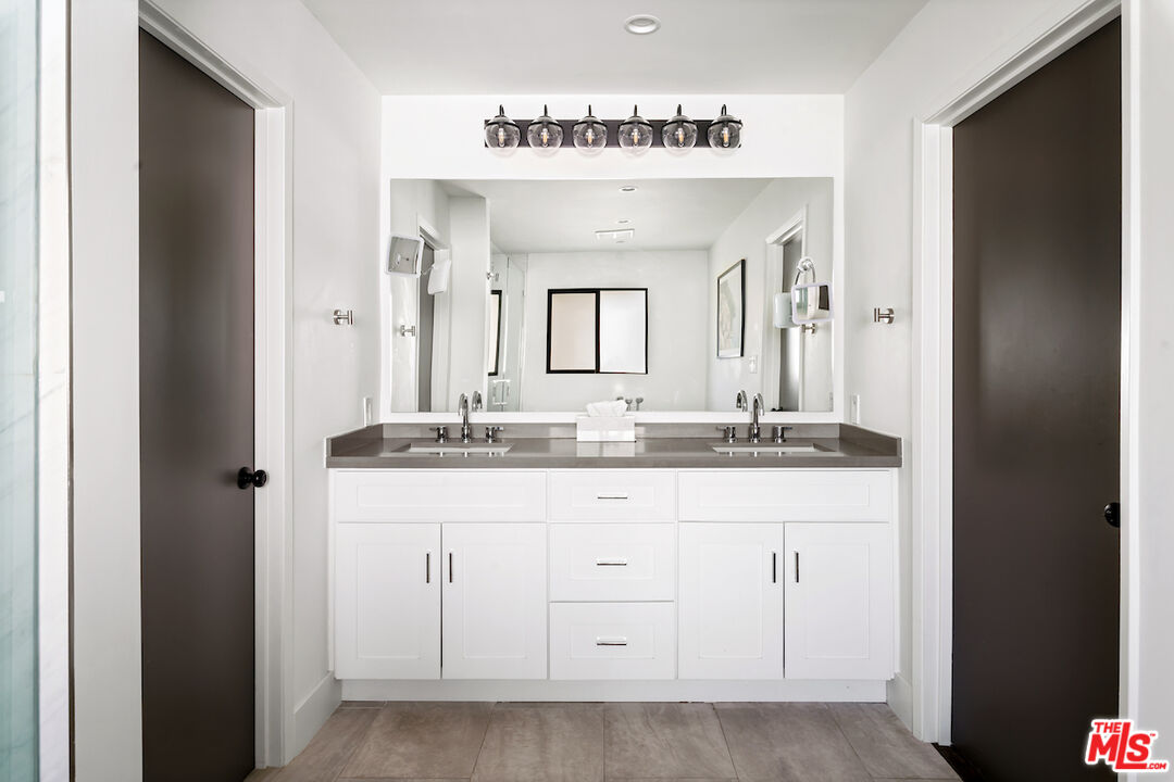 17003 Rancho Street Encino, CA 91316 - Photo 20 of 29 a bathroom with a granite countertop sink two mirror and a