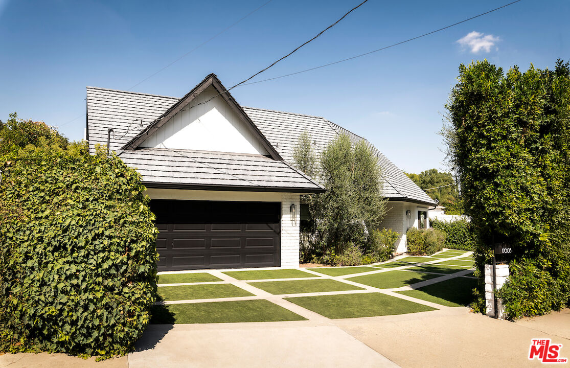 17003 Rancho Street Encino, CA 91316 - Photo 3 of 29 a view of a house with a yard and garage