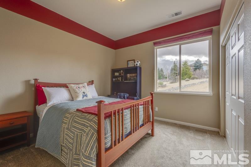 5265 North Elk River Road Reno, NV 89511 - Photo 19 of 25 a bed sitting in a bedroom next to a window