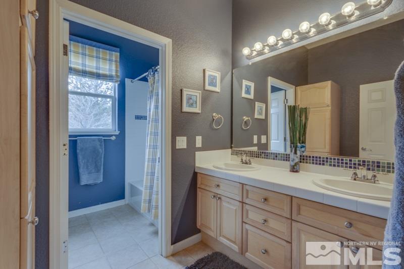 5265 North Elk River Road Reno, NV 89511 - Photo 21 of 25 a spacious bathroom with a double vanity sink a large mirror and a shower