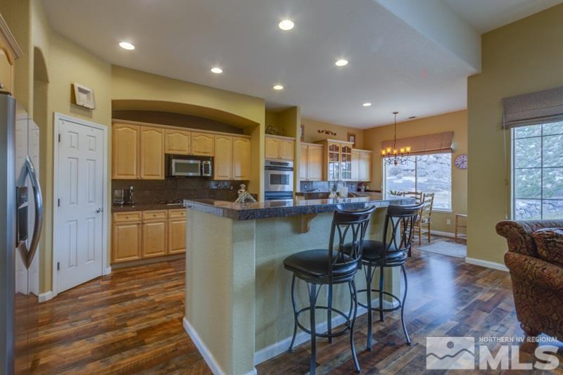 5265 North Elk River Road Reno, NV 89511 - Photo 7 of 25 a kitchen with stainless steel appliances granite countertop dining table chairs refrigerator and sink