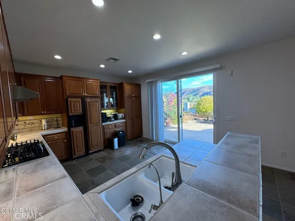a large kitchen with stainless steel appliances granite countertop a stove a sink and a microwave