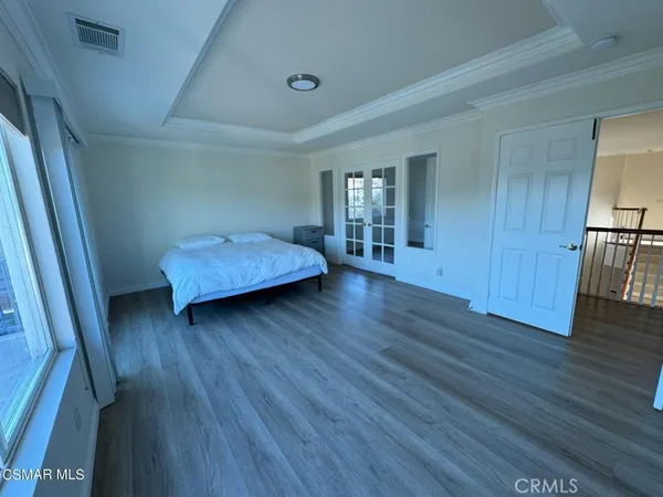 a view of a big room with wooden floor and windows