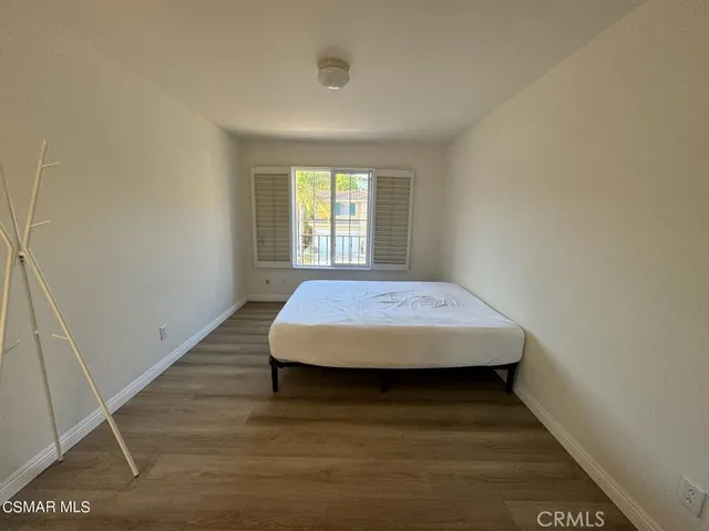 a bed sitting in a bedroom next to a window