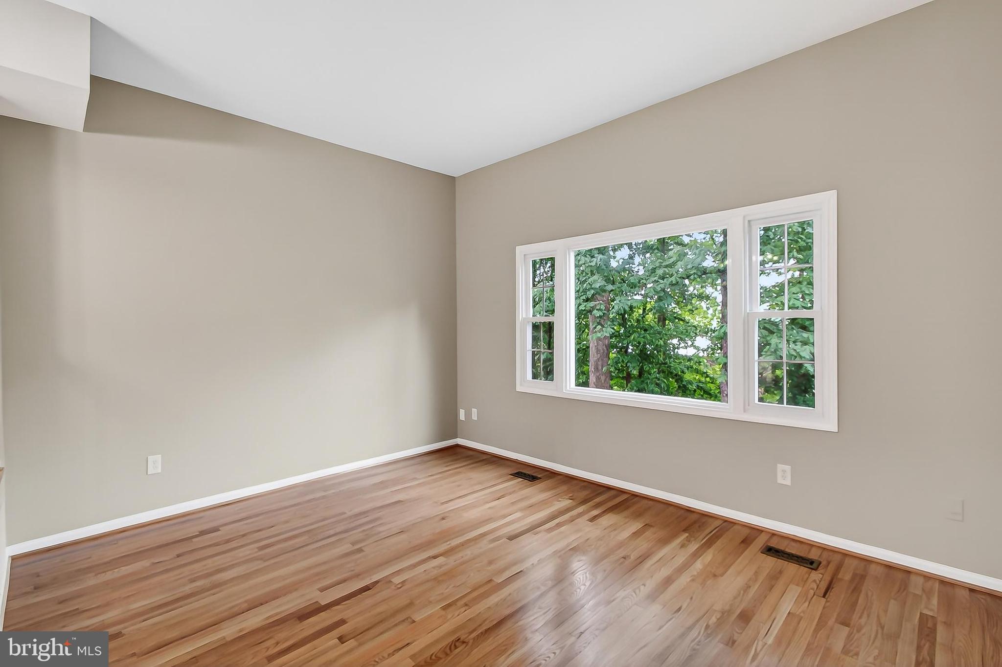 5833 Royal Ridge Drive, Unit 943 Springfield, VA 22152 - Photo 6 of 45 a view of an empty room with wooden floor and a window