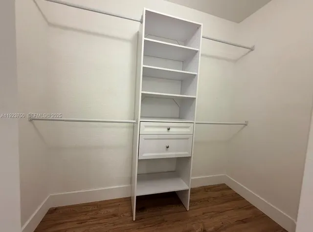 a view of walk in closet with empty racks