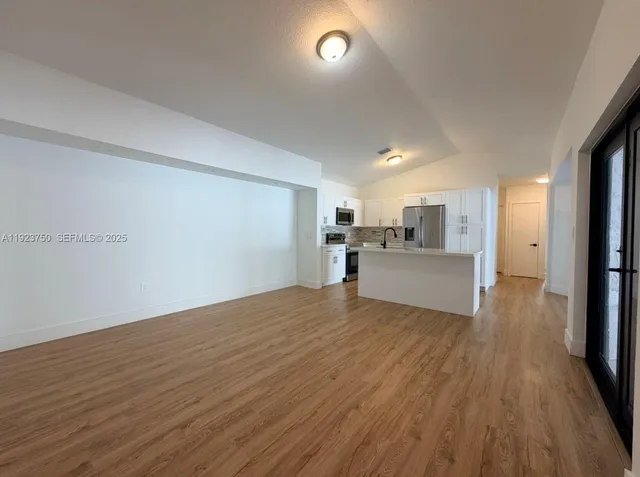 a view of a kitchen with a sink and a refrigerator