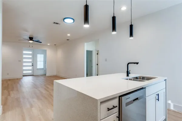 a kitchen with a sink cabinets and wooden floor
