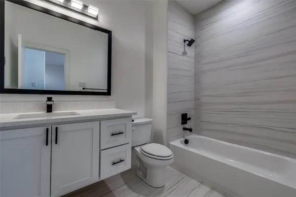 a bathroom with a toilet a sink a mirror and bathtub