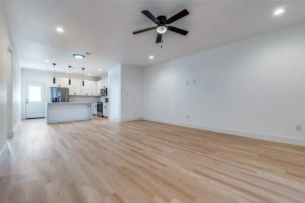 a view of empty room with wooden floor and windows