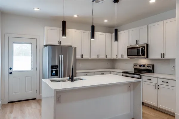a kitchen with stainless steel appliances a refrigerator sink and microwave