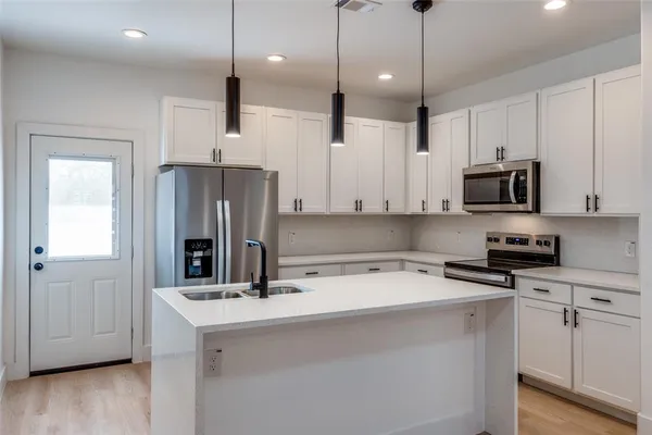 a kitchen with stainless steel appliances a refrigerator sink and microwave