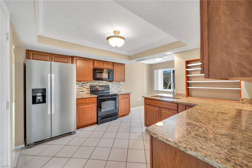 224 Potomac Place Naples, FL 34112 - Photo 7 of 17 a kitchen with stainless steel appliances granite countertop a refrigerator and a stove top oven