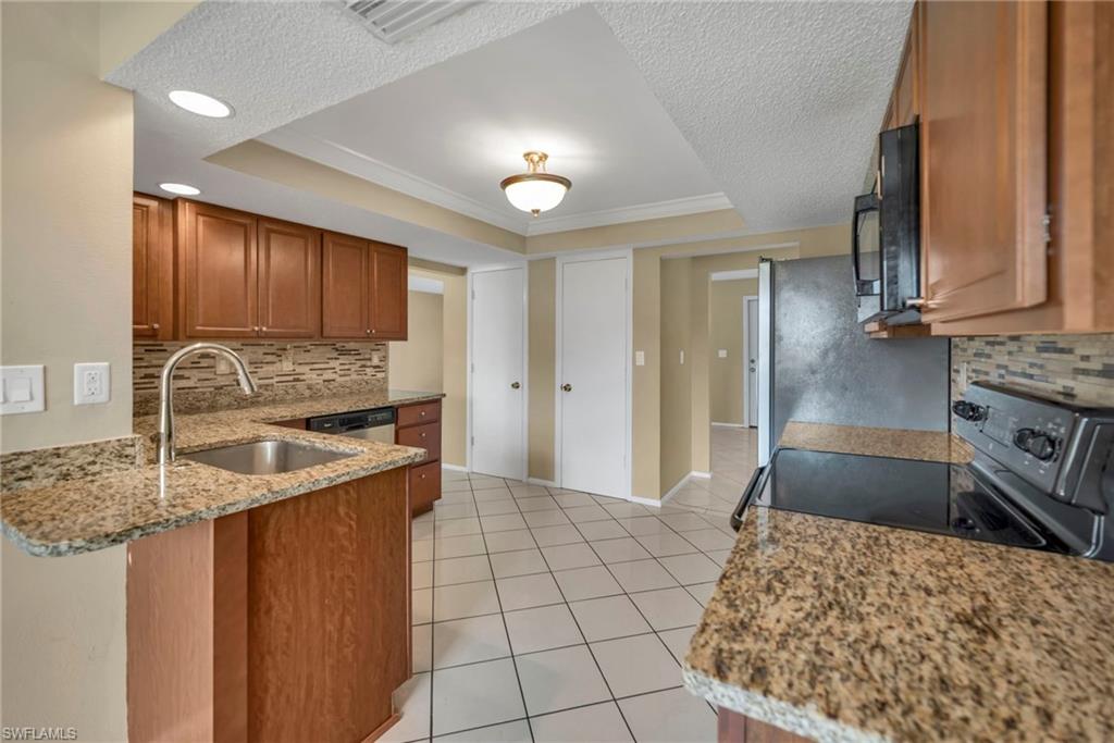 224 Potomac Place Naples, FL 34112 - Photo 9 of 17 a kitchen with stainless steel appliances granite countertop a sink stove and cabinets