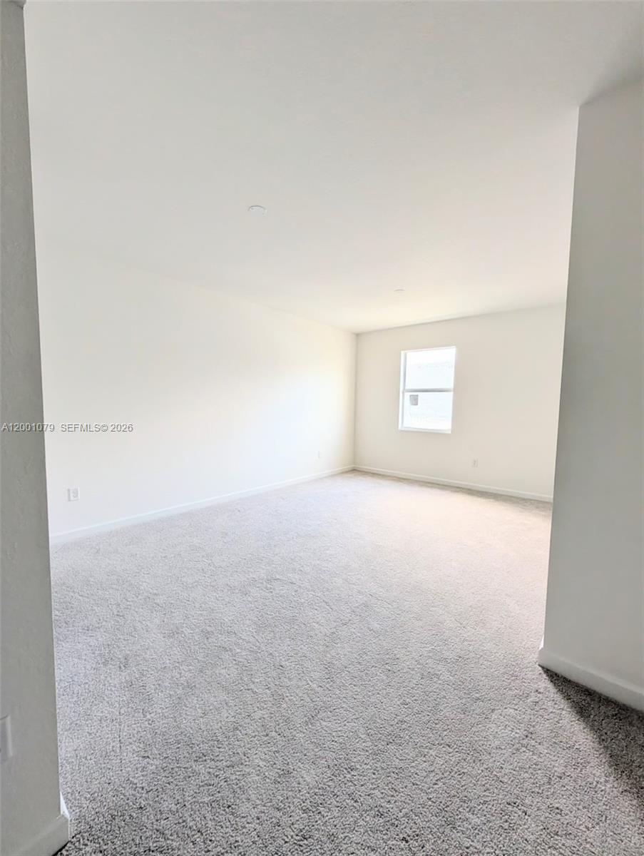 12476 Southwest 248th Street, Unit 5 Homestead, FL 33032 - Photo 6 of 10 an empty room with a empty space and a window
