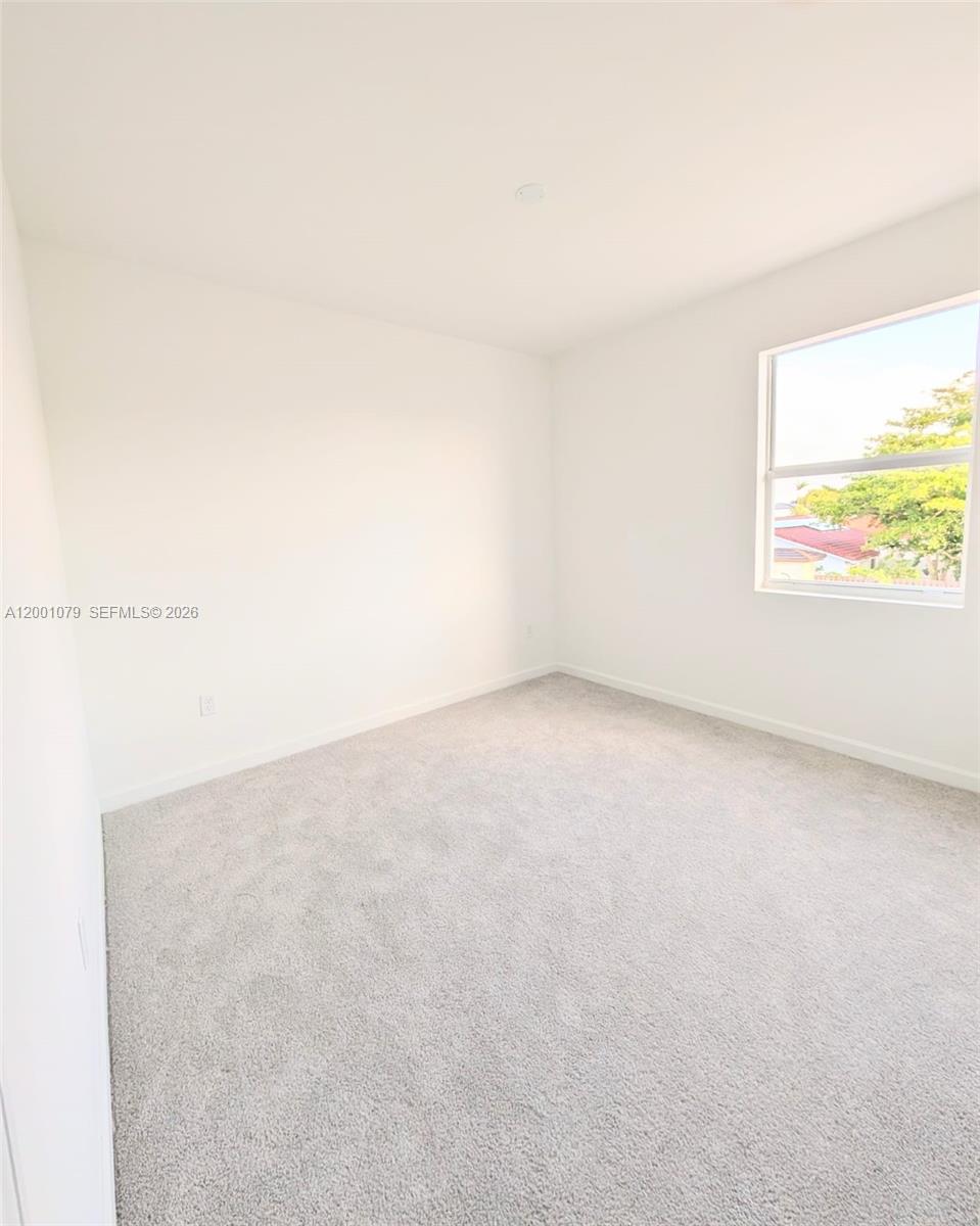 12476 Southwest 248th Street, Unit 5 Homestead, FL 33032 - Photo 7 of 10 a view of an empty room and a window