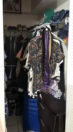 a view of walk in closet with clothes and shoes