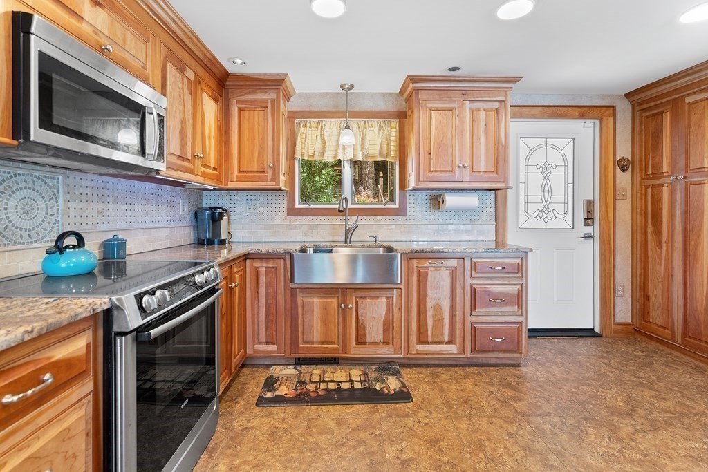 40 Over The Top Road Holland, MA 01521 - Photo 14 of 41 a kitchen with stainless steel appliances granite countertop a stove a sink and a microwave