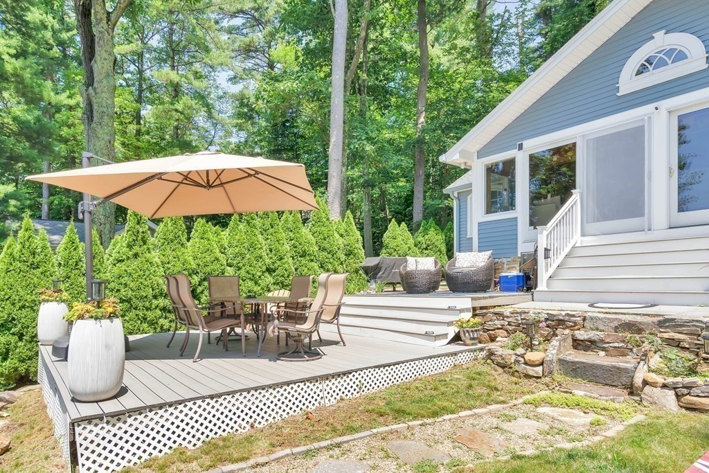 40 Over The Top Road Holland, MA 01521 - Photo 30 of 41 a view of a patio with table and chairs potted plants with wooden floor