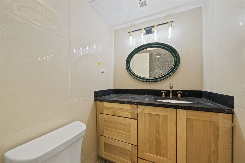 12 Sabrina Farm Wellesley, MA 02482 - Photo 14 of 16 a bathroom with a granite countertop toilet a sink and a mirror