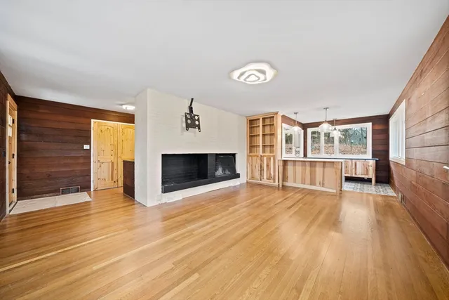 an empty room with wooden floor and fireplace