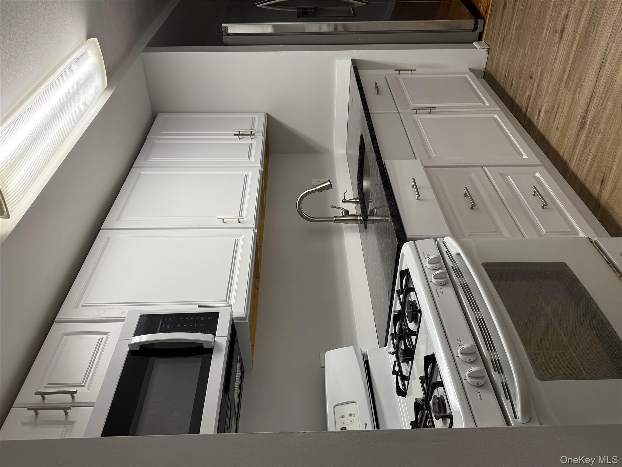 258 North Main Street, Unit C3 Spring Valley, NY 10977 - Photo 2 of 10 a kitchen with granite countertop white cabinets and stainless steel appliances