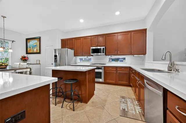 a kitchen with stainless steel appliances granite countertop a sink counter space and a refrigerator