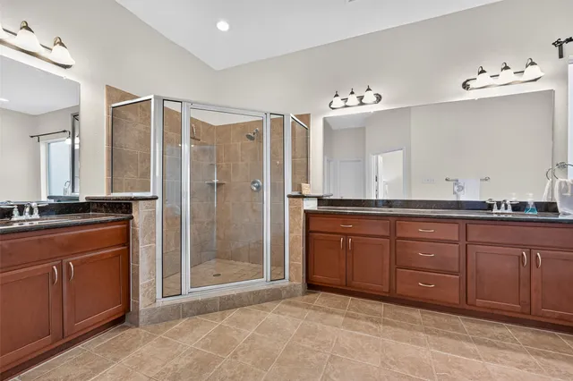 a bathroom with a granite countertop sink mirror and shower